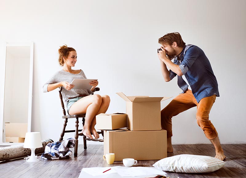 Un home prend une femme en photo dans un déménagement